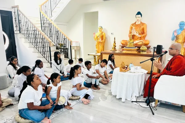 Monk teaching children in shrine room